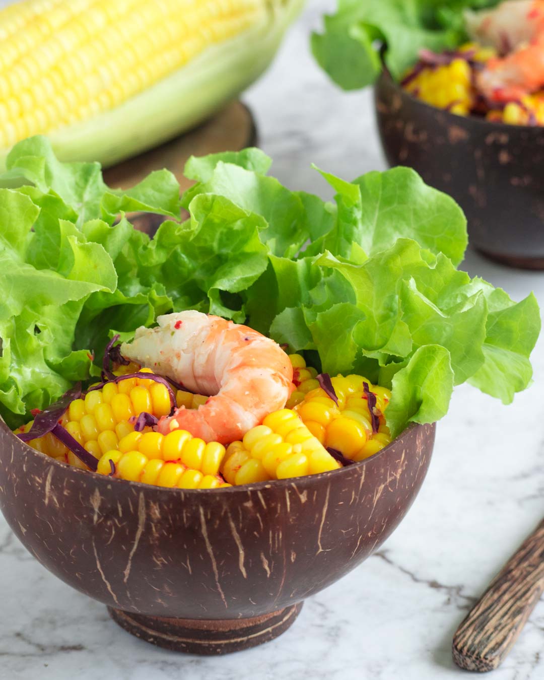 dairy free thai corn salad with prawn in a coconut shell bowl