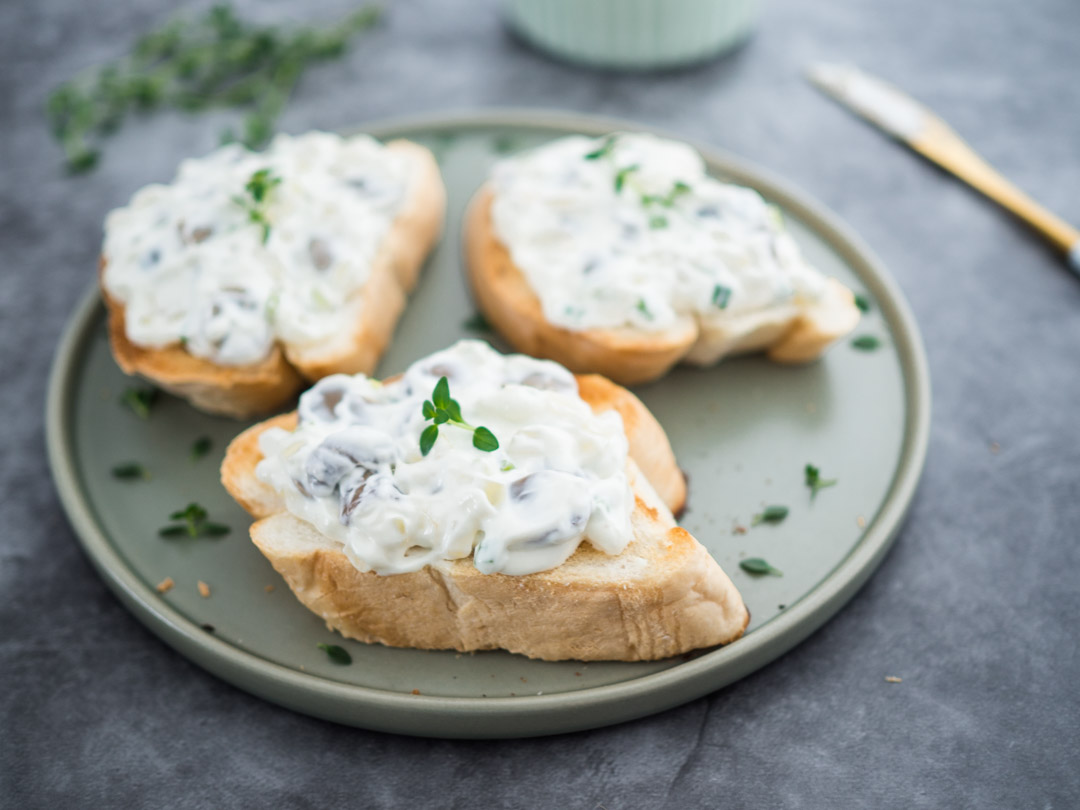 toast topped with sour cream and onion mushroom spread and a bowl of sour cream and onion mushroom spread