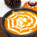 a cup of spooky Halloween soup with a spiderweb