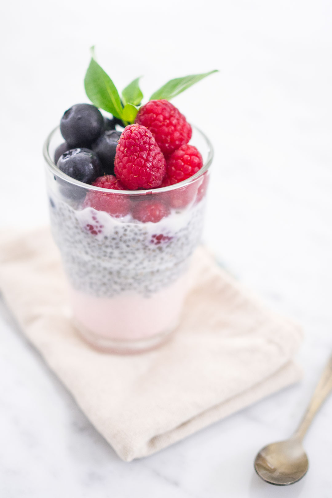 a glass of berry chia pudding with yogurt