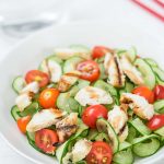 chicken tomato cucumber salad in a white dish