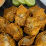 crispy air fryer wontons stuffed with pork on a serving plate