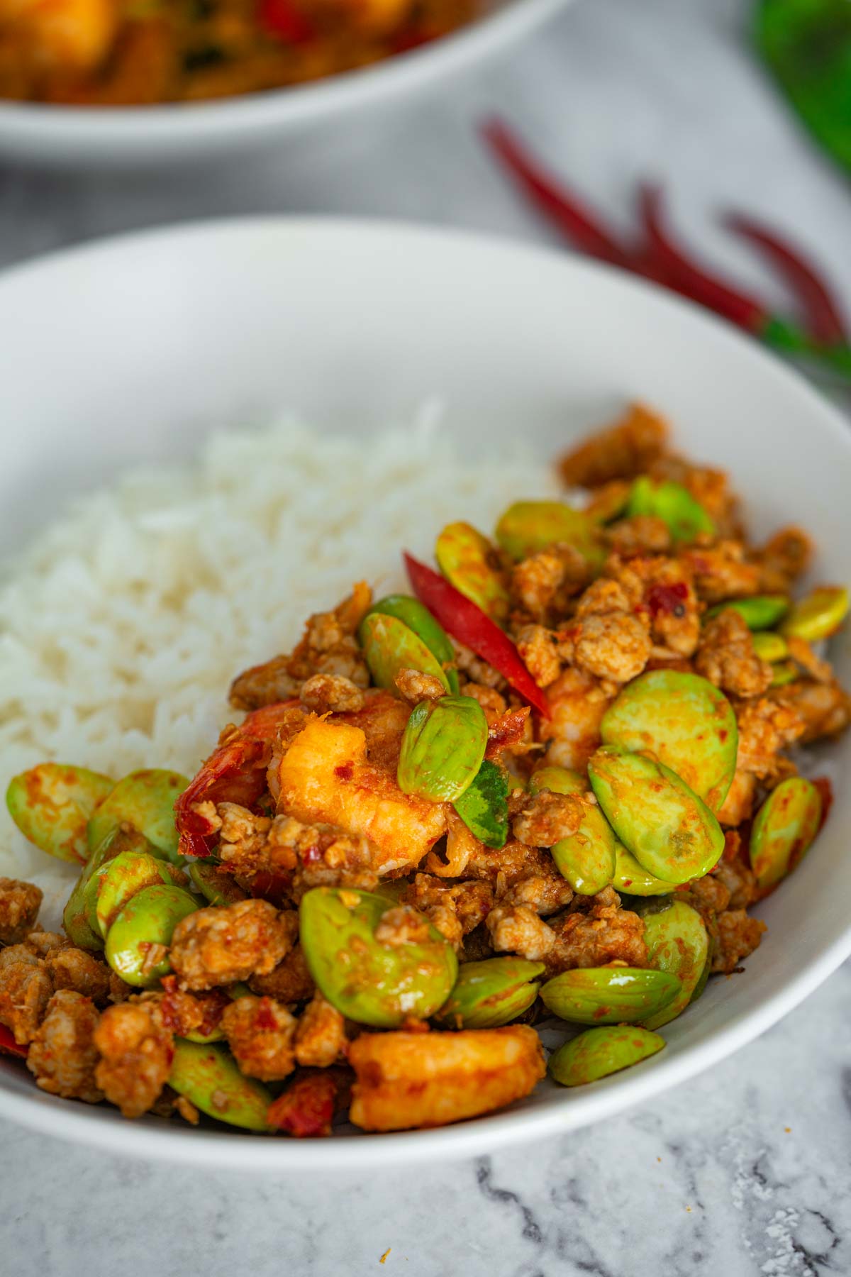 Thai stir fried stink beans with shrimp with rice in a white dish