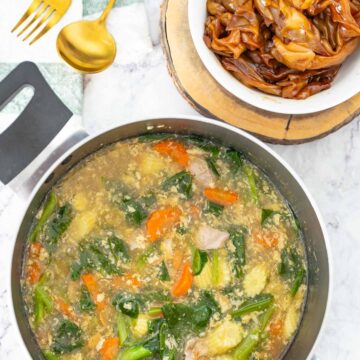 Thai rad na - a pot of pork gravy with rice noodles on a marble surface