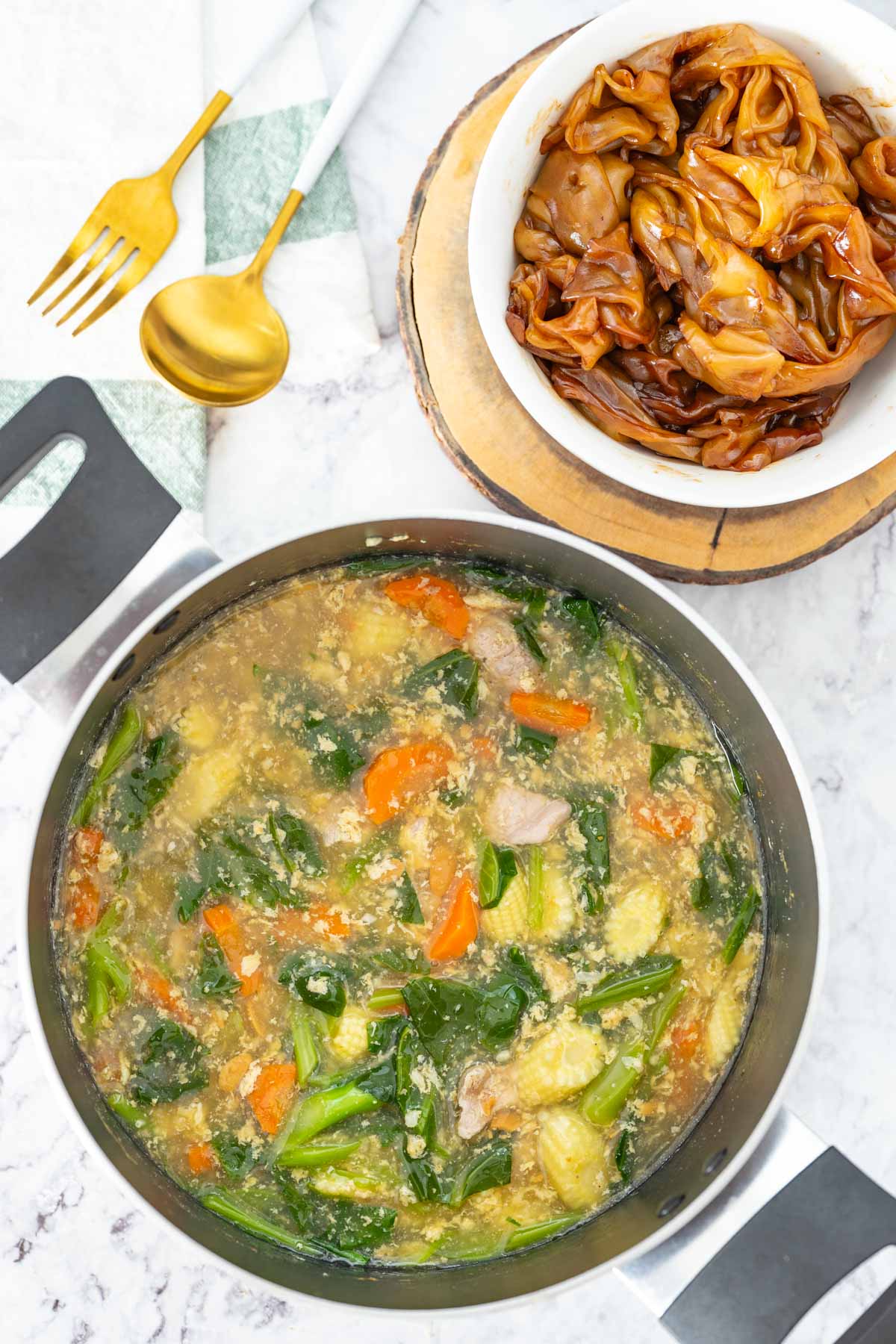 Thai rad na - a pot of pork gravy with rice noodles on a marble surface