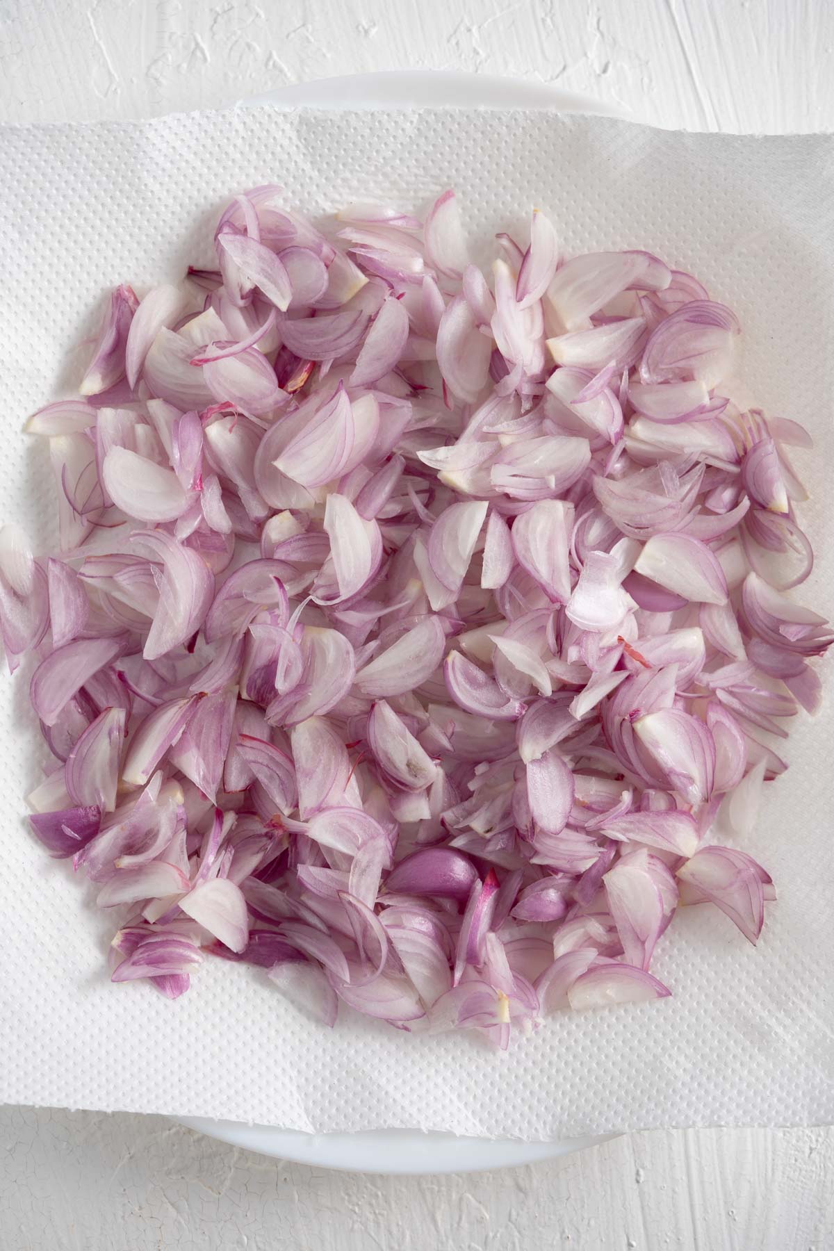 freshly sliced shallots on a paper towel