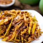 Thai green mango salad on a white plate
