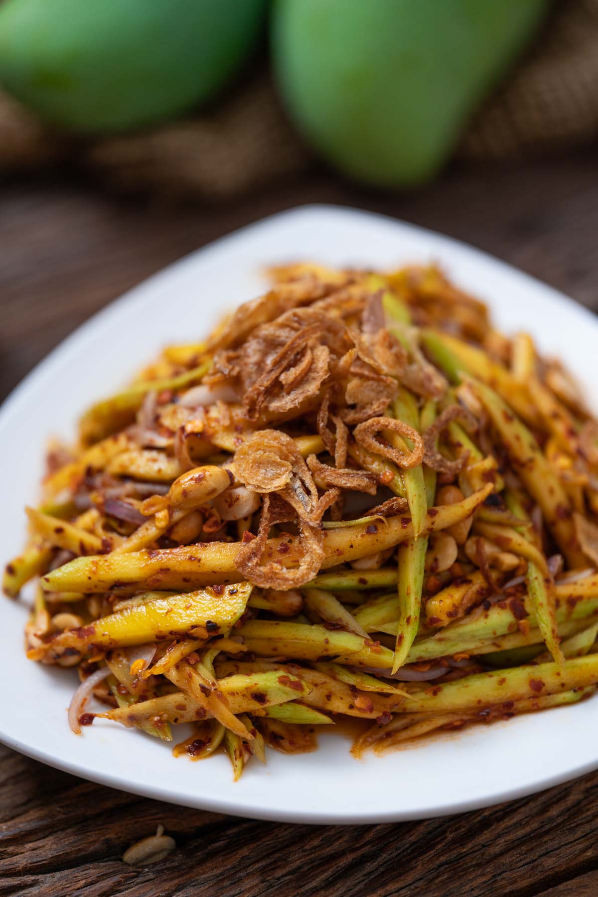 Thai green mango salad on a white plate